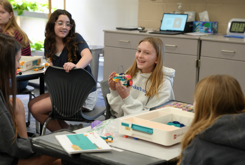student presents her Lego project to classmates